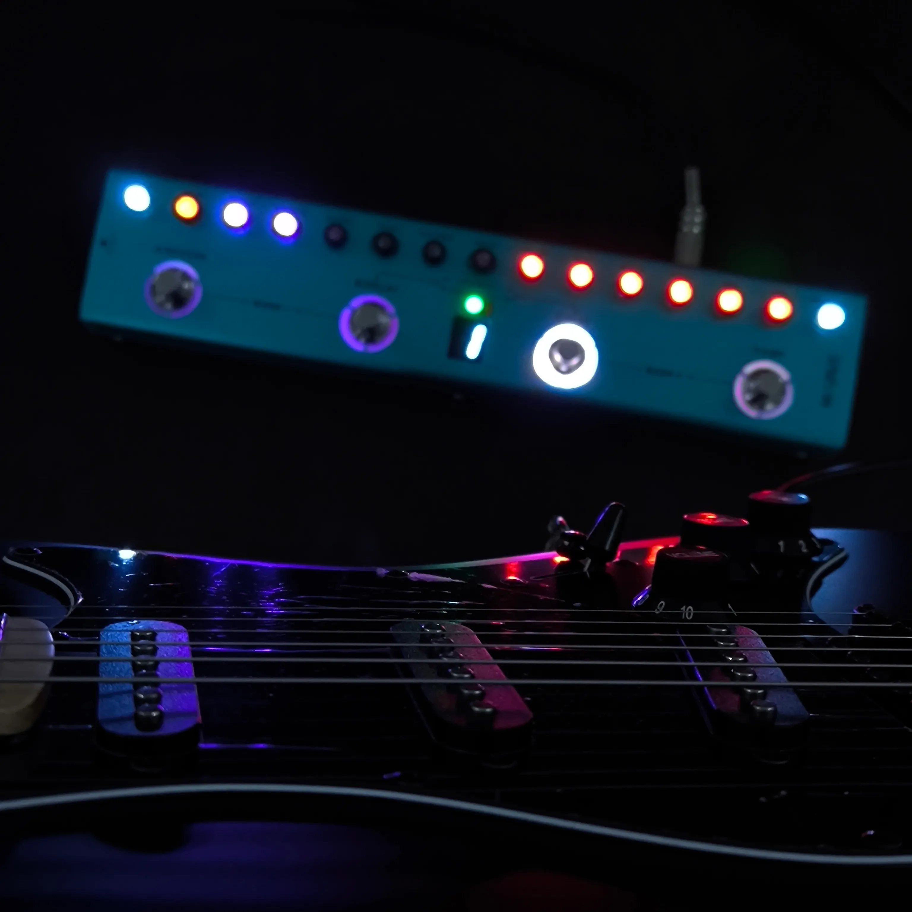Guitarra elétrica e pedaleira com iluminação colorida